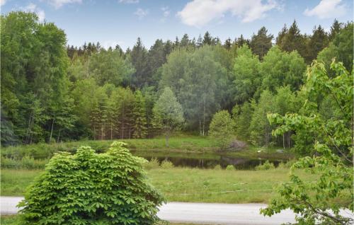 a pond in the middle of a field with trees at Awesome Home In Asarum With Wifi in Asarum