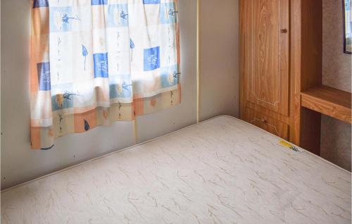 een bed in een kamer met een gordijn bij 2 Bedroom Lovely Home In Legbad in Legbąd