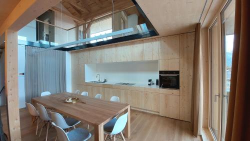 a kitchen and dining room with a wooden table and chairs at Kranzmuehle - Ankommen am Achensee in Achenkirch