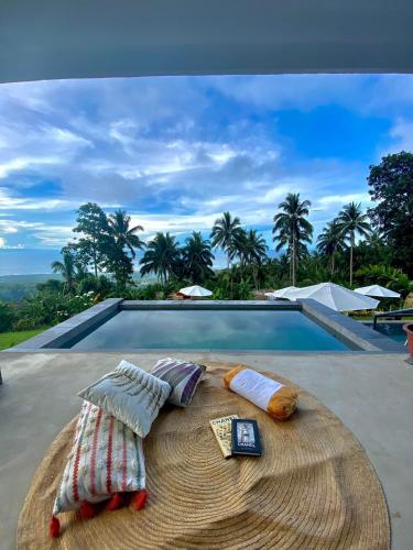 two pillows and towels sitting on a rug next to a swimming pool at Bintana sa Paraiso Binunsaran in Mambajao