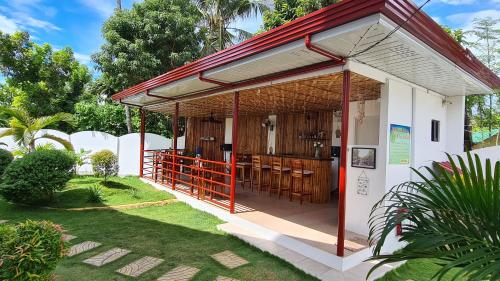 a small building with a porch with a bar at Roos Guesthouse in Moalboal