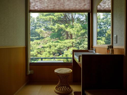ein Bad mit einem Fenster mit Waldblick in der Unterkunft Matsusaki in Nomi