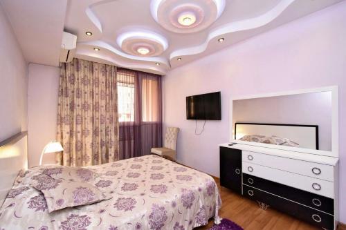 a bedroom with a bed and a tv on the ceiling at Three Rooms Center Yerevan 6 in Yerevan