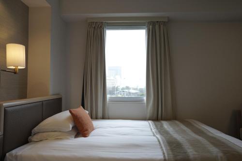 a bedroom with a bed with a large window at Akasaka Excel Hotel Tokyu in Tokyo
