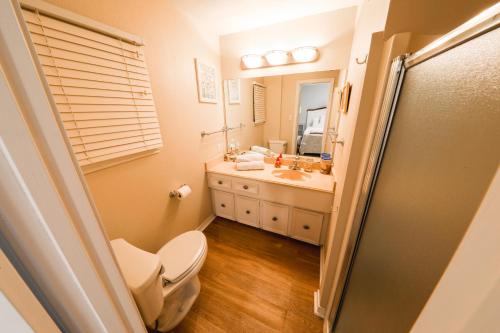 a bathroom with a toilet and a sink and a mirror at Beach Mode ON! in Galveston