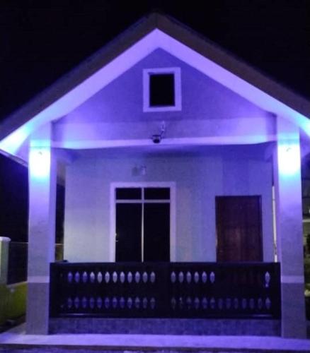 een huis met paarse lichten ervoor bij Inap Desa 1 