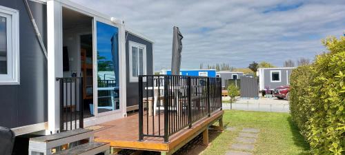 une terrasse couverte à l'avant d'une maison avec une clôture dans l'établissement Self Contained 2BR holiday unit in Richmond Tasman, à Richmond