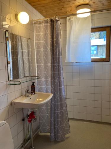 a bathroom with a sink and a shower curtain at Stuga Huså Åre in Huså