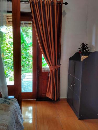 a room with a door with a curtain and a bed at Sumatra Orangutan Discovery Villa in Bukit Lawang