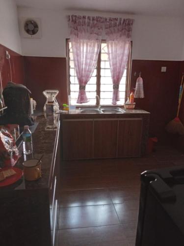 een woonkamer met een tafel en een raam bij Narayana Illam in Nilai