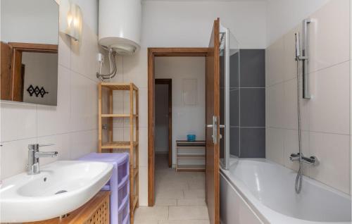 a bathroom with a sink and a bath tub at Cozy Apartment In Njivice With Kitchen in Njivice