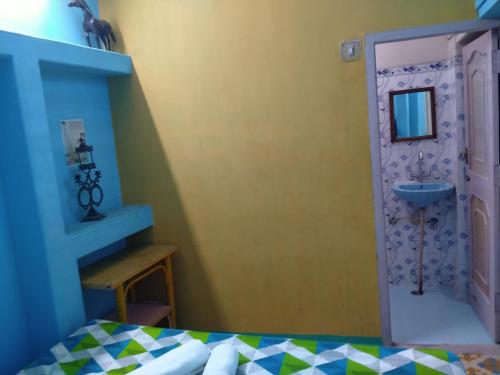 um quarto com uma cama e uma casa de banho com um lavatório em Golden Dreams Guest House em Jodhpur
