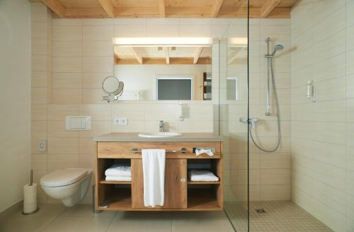 ein Bad mit einem Waschbecken, einem WC und einer Dusche in der Unterkunft See- und Waldresort Gröbern in Gröbern