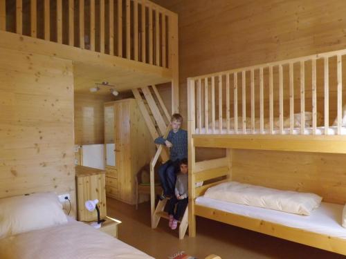 zwei Kinder auf Etagenbetten in einer Hütte in der Unterkunft Feriendorf am Hahnenkamm in Reutte