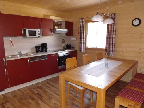 uma cozinha e sala de jantar com uma mesa de madeira em Feriendorf am Hahnenkamm em Reutte