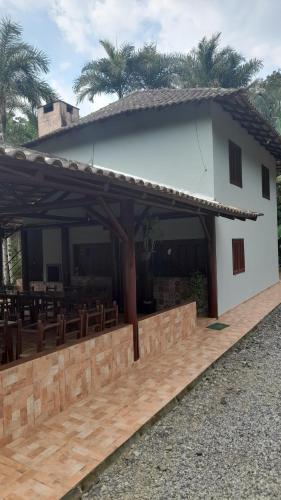 a building with a table and chairs in front of it at Casa de campo Rosa dos ventos in Rodeio