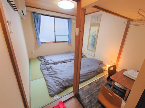 a small room with a bed and a mirror at Stay Inn KOTO in Kyoto