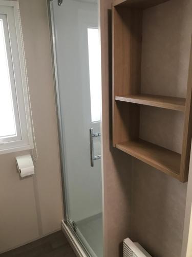 a bathroom with a shower and a glass door at MH-6 PERS-3 CH-2 SDB-lave vaisselle-lave linge - WIFI GARANTIE - grande terrasse in Pont-Aven