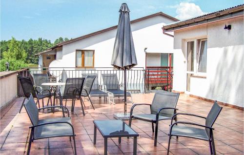 un patio con tavolo, sedie e ombrellone di Four-Bedroom Holiday Home In Sianow a Sianów