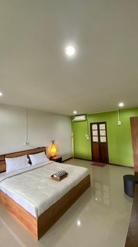 a bedroom with a large bed with green walls at ภูคำฮ้อมคลิฟฟ์ลอดจ์ แอนด์ โฮมสเตย์ Phu come home cliff Lodge & Homestay in Ban Phu Hi