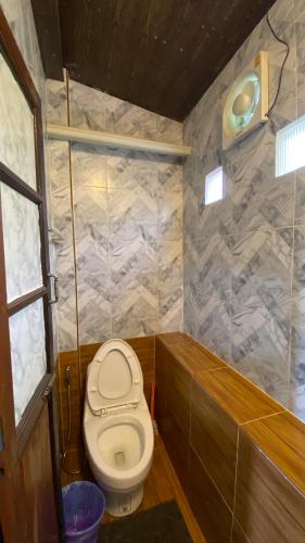 a small bathroom with a toilet and a tub at ภูคำฮ้อมคลิฟฟ์ลอดจ์ แอนด์ โฮมสเตย์ Phu come home cliff Lodge & Homestay in Ban Phu Hi
