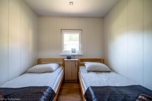 sypialnia z 2 łóżkami i oknem w obiekcie Wilimy, Domek Przy Stawie w mieście Biskupiec