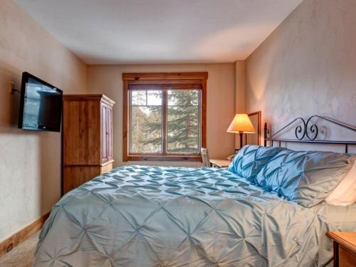 Un dormitorio con una cama grande y una ventana en Luxury 2 Bedroom Mountain Vacation Rental In Breckenridge With Access To A Hot Tub And Heated Garage Parking, en Breckenridge
