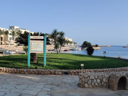 a sign in the grass next to a body of water at Hawana Salalah Laguna Studio in Salalah