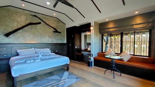 1 dormitorio con 1 cama y una gran pintura en la pared en Rongna Villas, en Ko Yao Noi