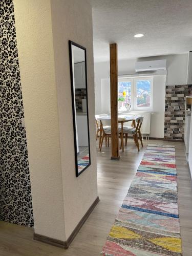 a dining room with a mirror and a table at Apartman Maki in Sarajevo