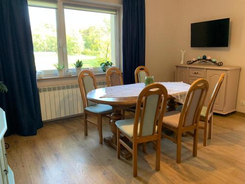 d'une salle à manger avec une table, des chaises et une fenêtre. dans l'établissement chillout w Rychwaldzie, à Żywiec