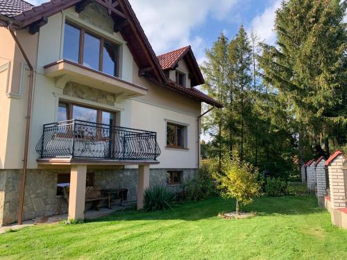 a house with a balcony and a yard at chillout w Rychwaldzie in Żywiec