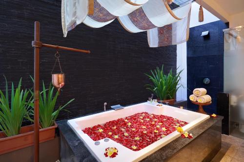 a bathroom with a bath tub filled with red peppers at Gending Kedis Luxury Villas & Spa Estate in Jimbaran
