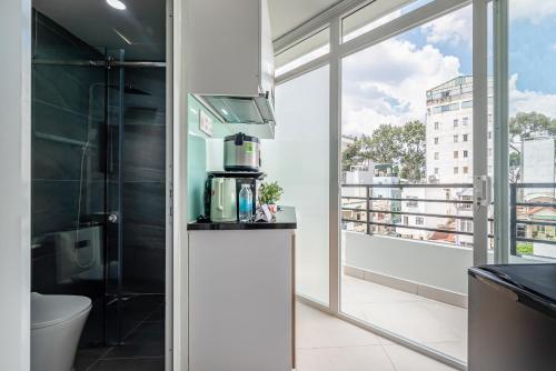 - une salle de bains avec une cafetière sur un comptoir à côté d'une fenêtre dans l'établissement Cozrum Homes - Retro House, à Hô-Chi-Minh-Ville