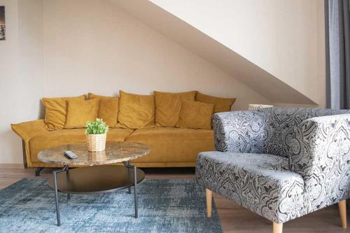 ein Wohnzimmer mit einem Sofa, einem Tisch und einem Stuhl in der Unterkunft Schiller-Quartier 6 in Bremerhaven