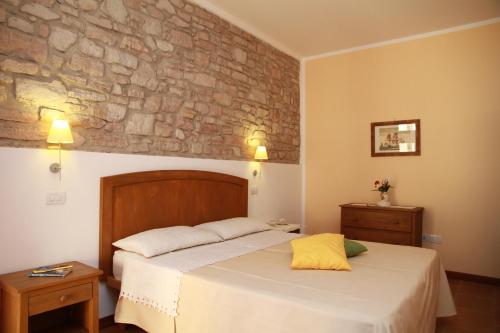 1 dormitorio con cama y pared de piedra en Agriturismo La Ronca, en San Vincenzo