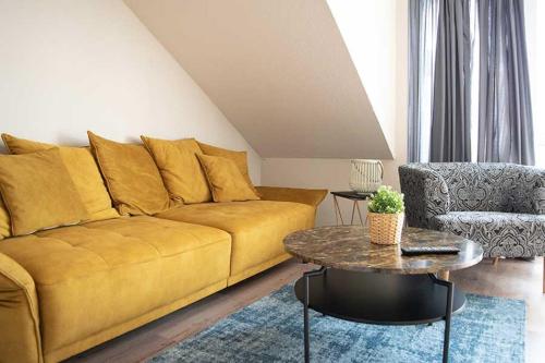 a living room with a yellow couch and a table at Schiller-Quartier 6 in Bremerhaven