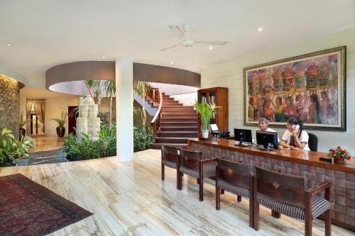 a lobby with a bar with two people sitting at a desk at Gending Kedis Luxury Villas & Spa Estate in Jimbaran