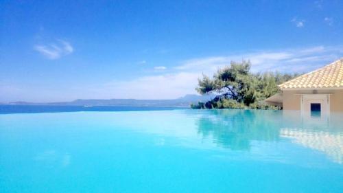 a blue and white house with a blue sky at 12 Gods Resort in Pylos