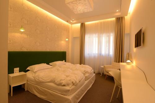 a bedroom with a large bed with a green headboard at Miramar Hotel Resort and Spa in Trâblous