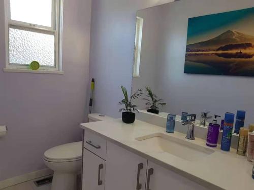 Baño blanco con aseo y lavamanos en private single room in a house, en Richmond