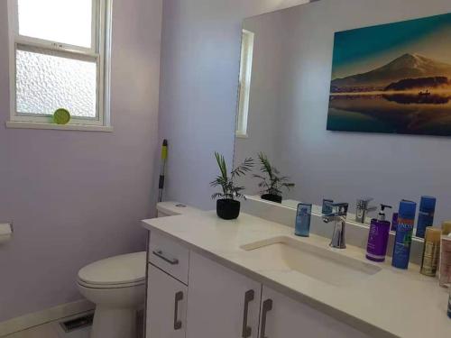 um banheiro branco com um vaso sanitário e uma pia em private single room in a house em Richmond