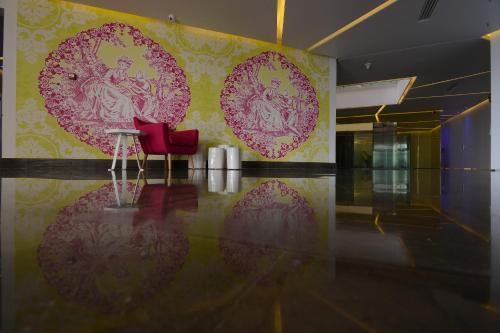 a room with red chairs and a wall with hearts at Miramar Hotel Resort and Spa in Trâblous