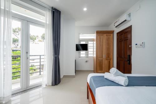 une chambre avec un lit et une grande fenêtre dans l'établissement Cozrum Homes - Retro House, à Hô-Chi-Minh-Ville