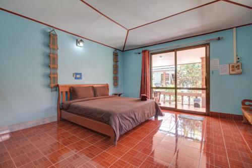 - une chambre avec un lit et une grande fenêtre dans l'établissement Sawai Home Resort, à Nathon