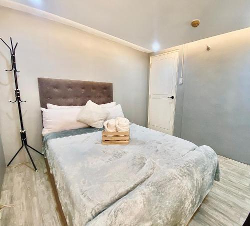 een slaapkamer met een groot bed met een statief bij IV’s Condo w/ Netflix, Wifi & Karaoke in Cainta