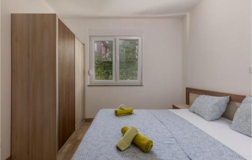 a bedroom with a bed with two yellow objects on it at Amazing Apartment In Njivice With Kitchen in Njivice