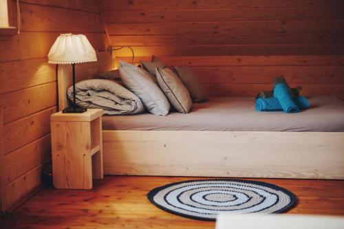 un letto in una baita di tronchi con un orsacchiotto sopra di Felusiowa Chata a Laskowa