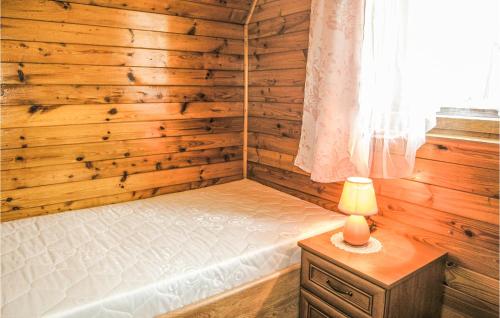 ein Schlafzimmer mit einem Bett und einer Lampe auf einem Tisch in der Unterkunft Stunning Home In Sobtka With Kitchen in Sulistrowiczki