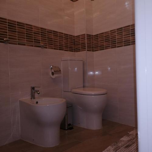 La salle de bains est pourvue de toilettes et d'un lavabo. dans l'établissement Dimora Genovesi, à Catane
